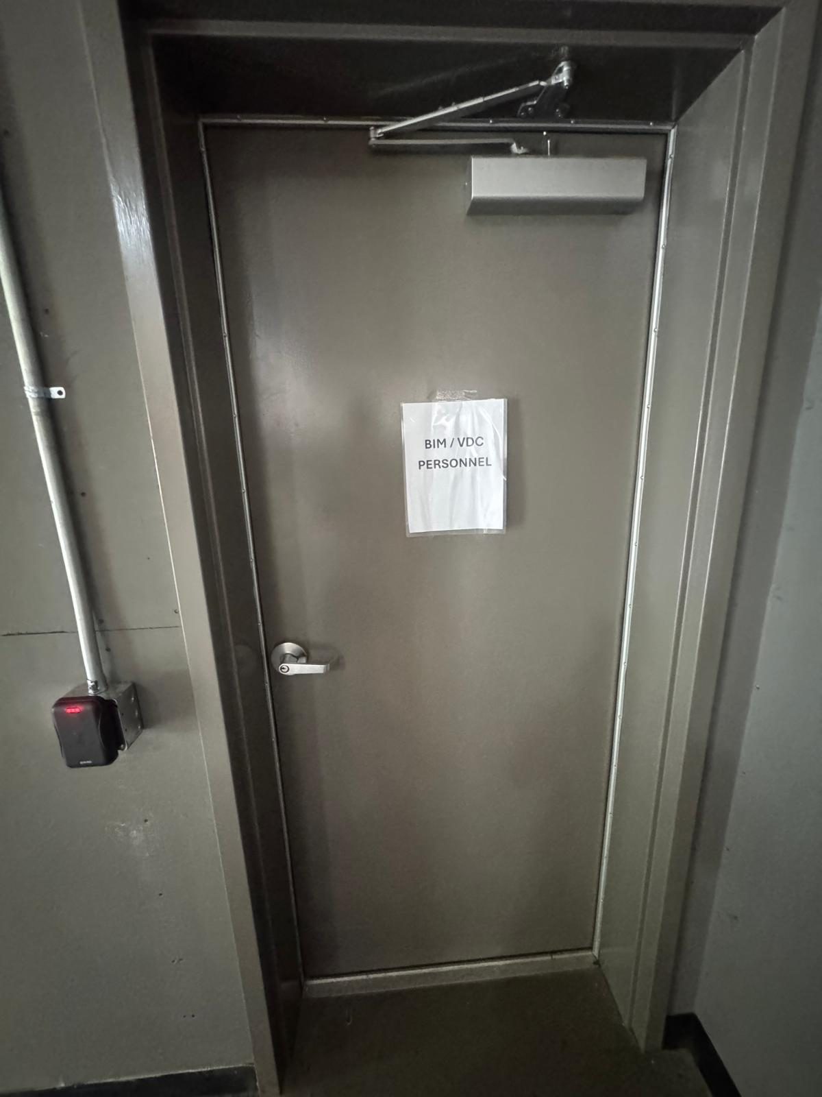 Commercial door fitted with an access control card reader and lever handle