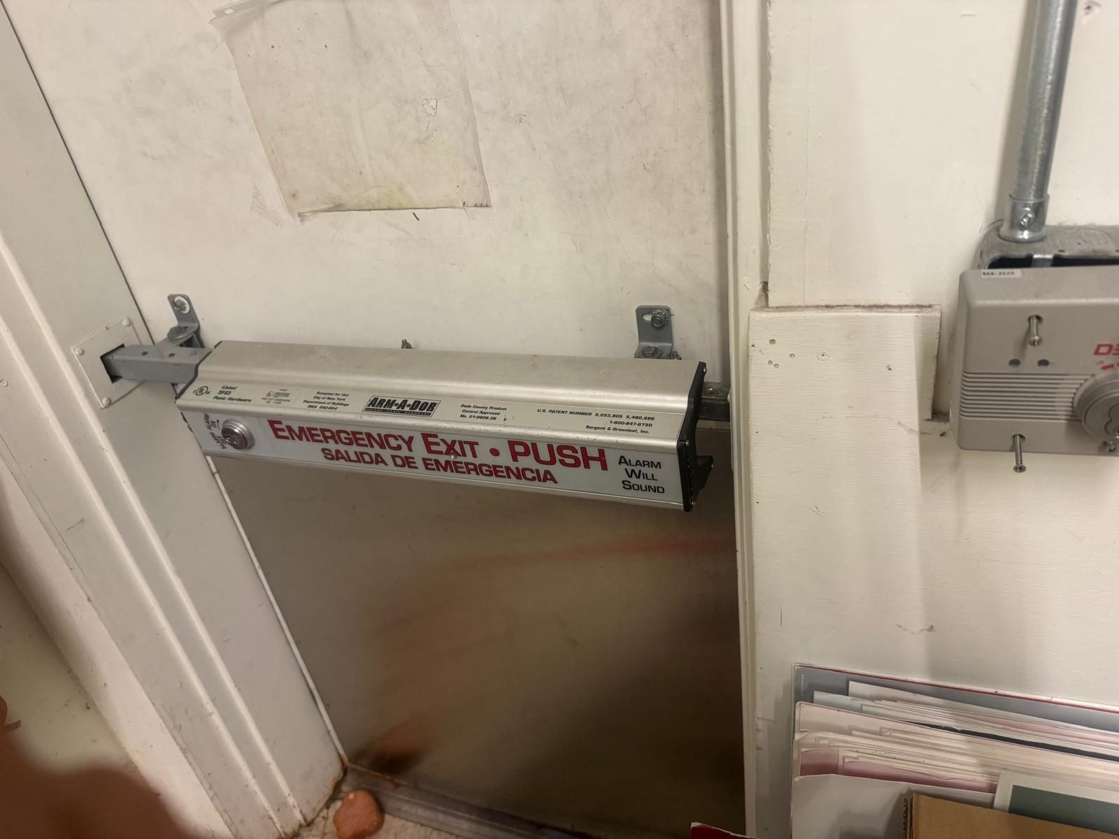 Emergency exit push bar hardware installed on an interior door